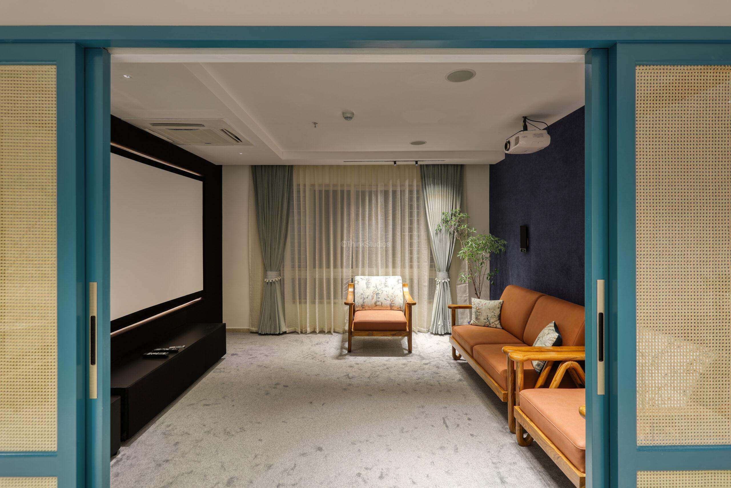 This is a home theater with traditional indian chairs and sofas